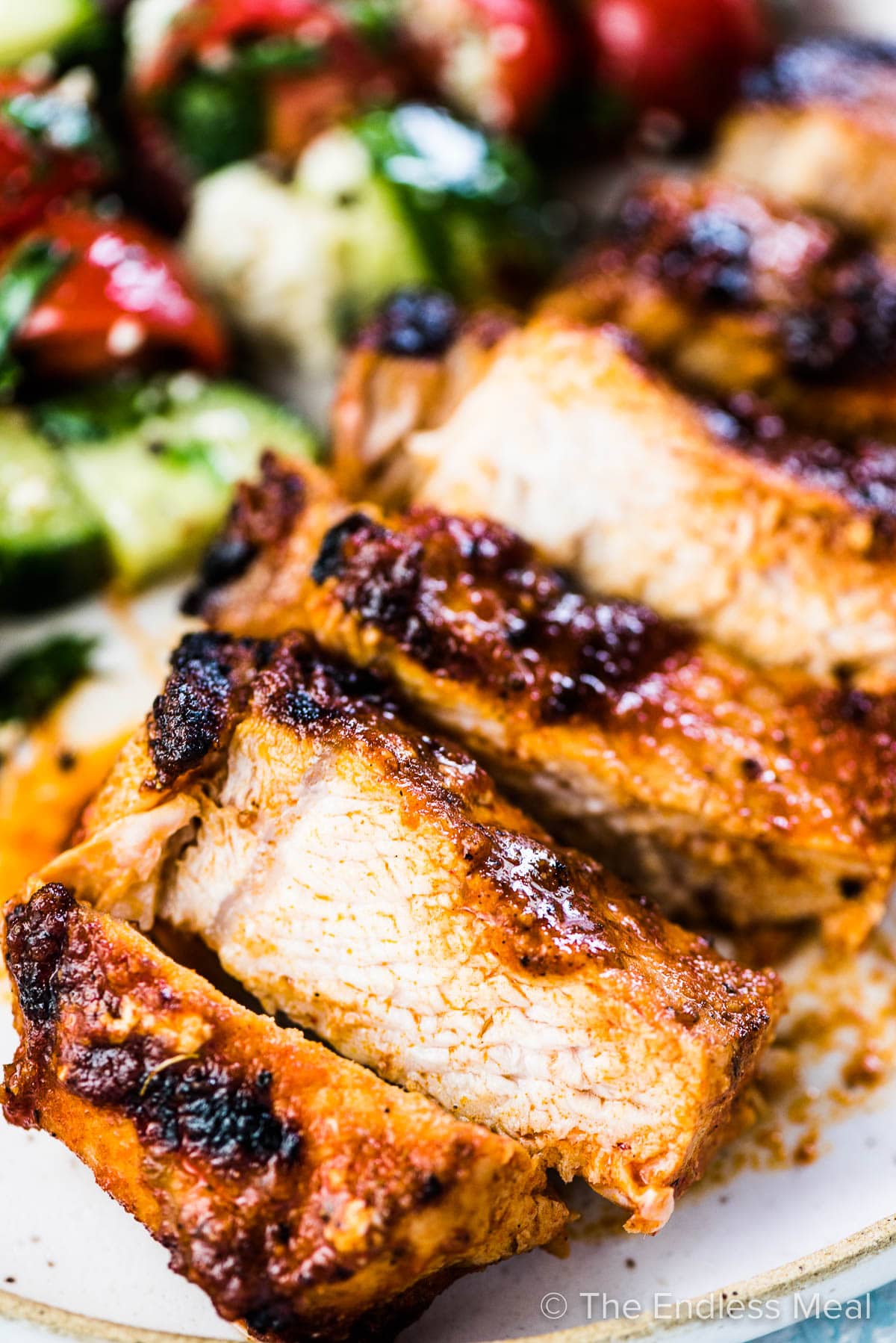 A close up of sliced juicy bbq pork chops on a dinner plate.