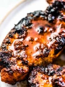 A close up of juicy grilled pork chops on a plate.