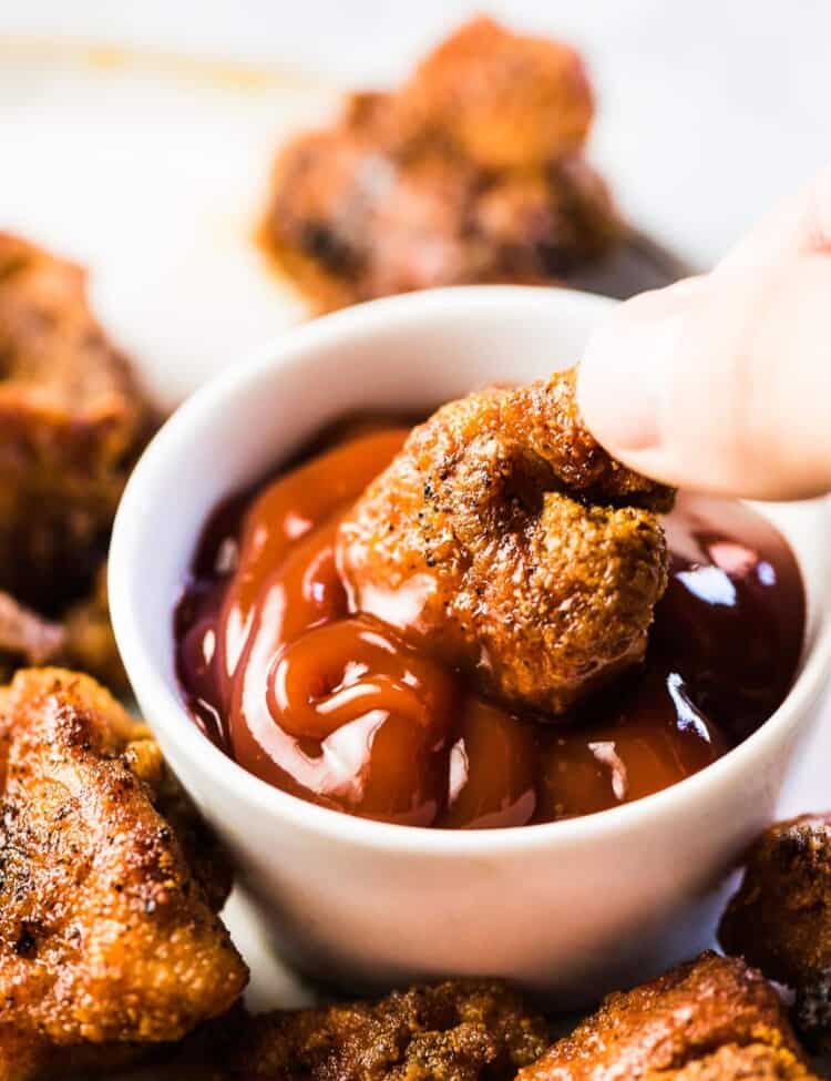 Easy chicken bites being dipped into ketchup.