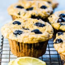Paleo blueberry muffins on a cooling rack with a few lemon slices.