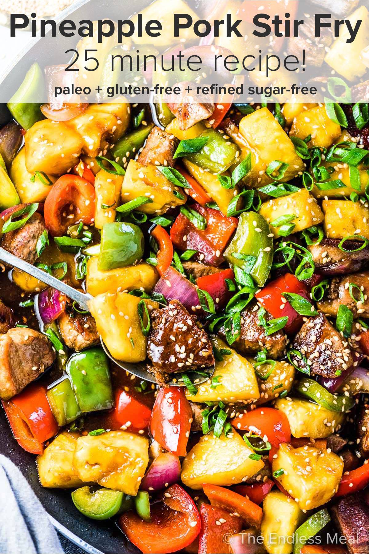 Pineapple and pork stir fry in a pan with the recipe title on top of the picture. 