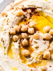 A close up shot of an easy hummus recipe with chickpeas and olive oil on top.