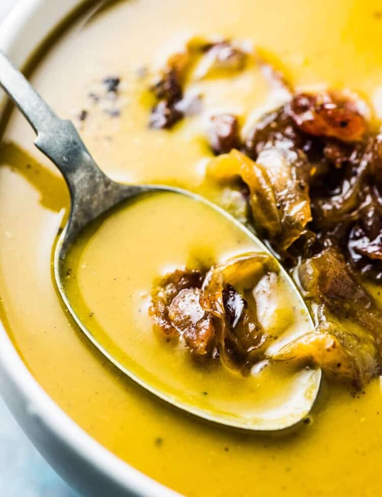 A spoon in a bowl of pumpkin soup.