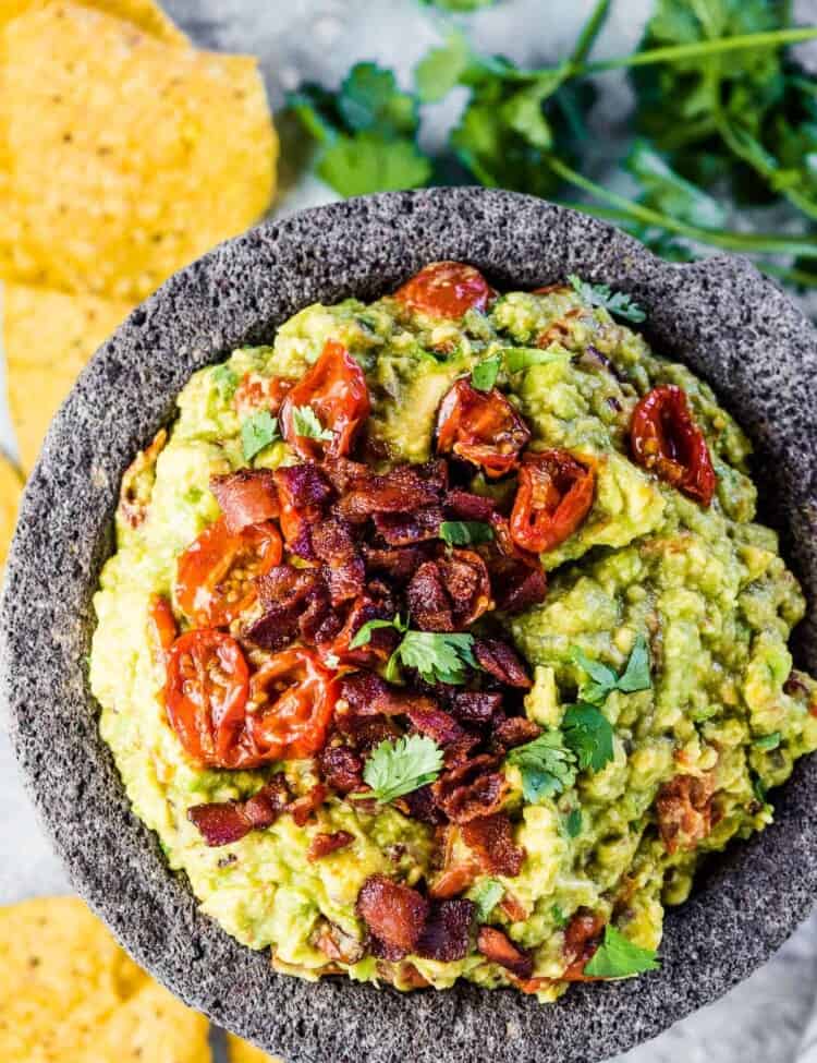 Bacon guacamole in a serving bowl with chips on the side.