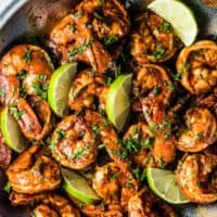 Chili lime shrimp in a pan with lime slices.