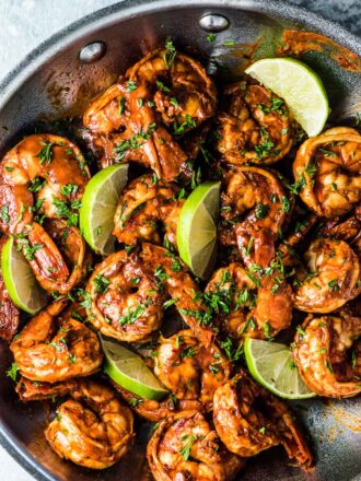 Chili lime shrimp in a pan with lime slices.