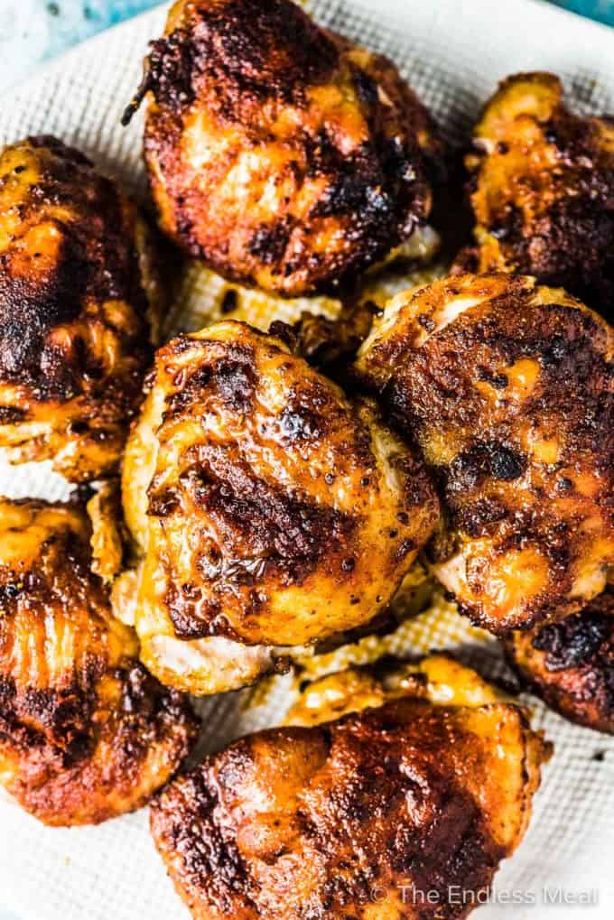 Baked chicken thighs on a white plate.