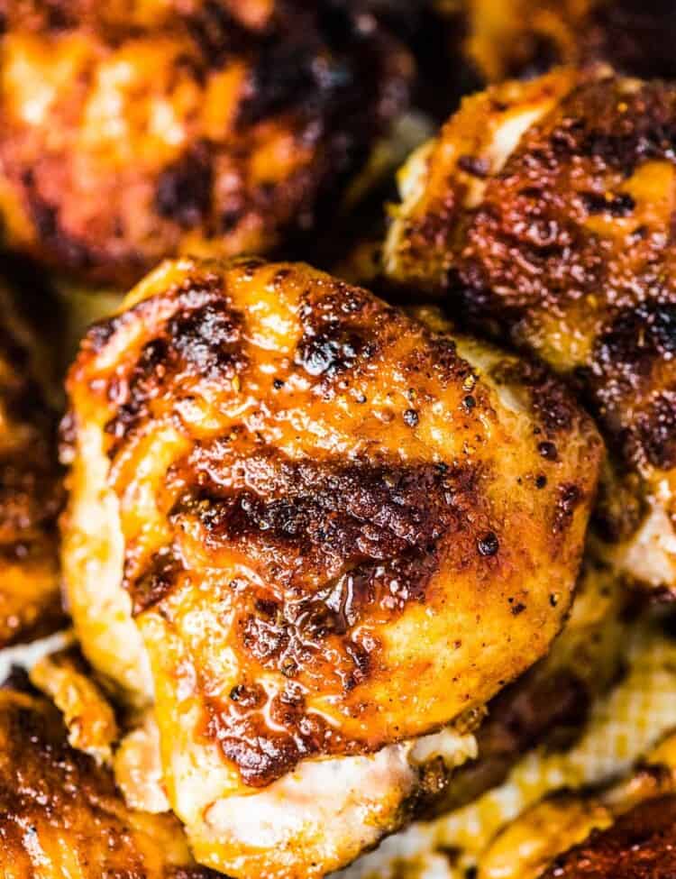 A close up of a stack of juicy baked chicken thighs.