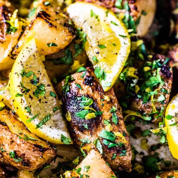 A close up of Greek lemon potatoes with a few slices of lemon on top.