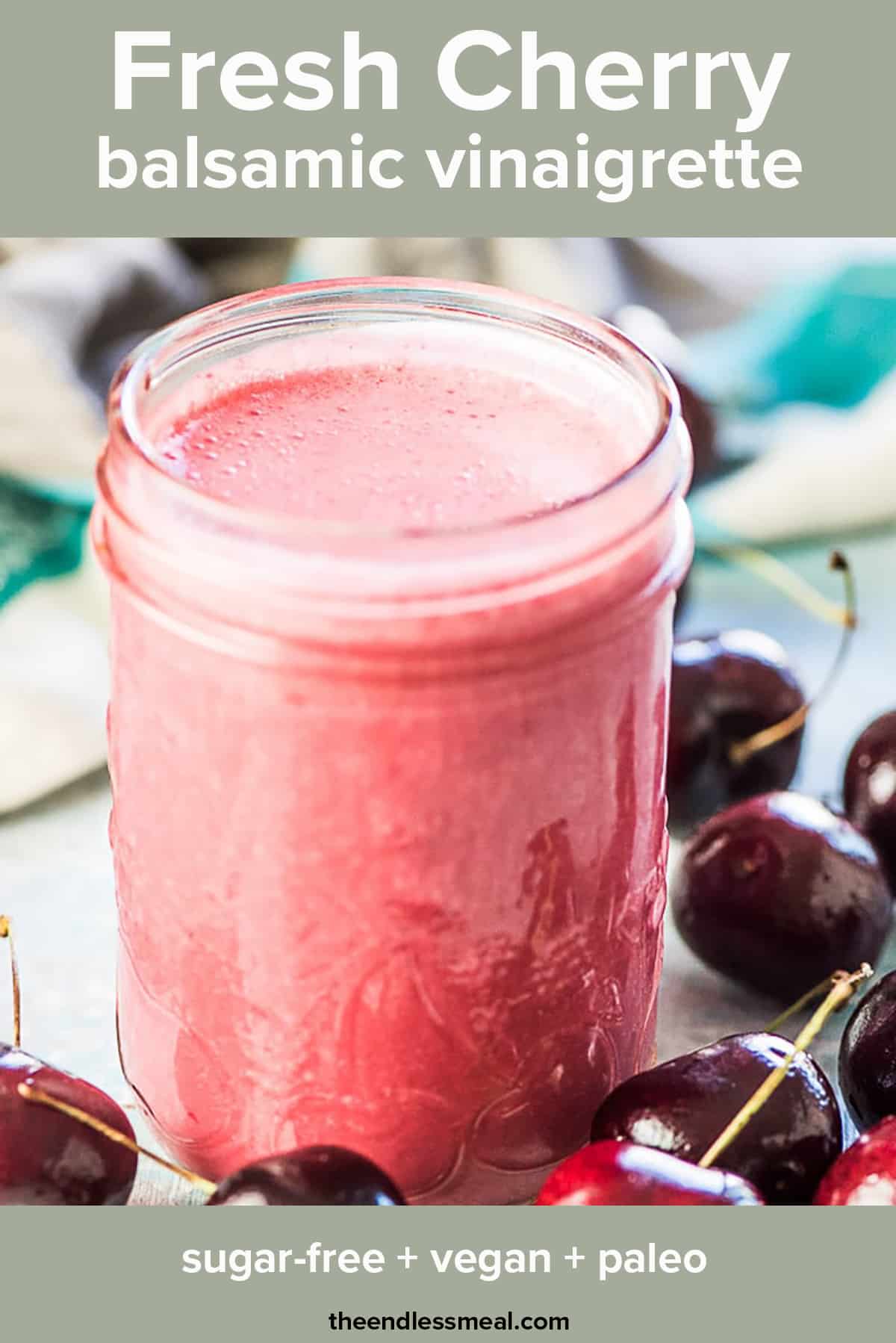 Cherry vinaigrette in a glass jar with cherries around it and the recipe title on top of the picture. 