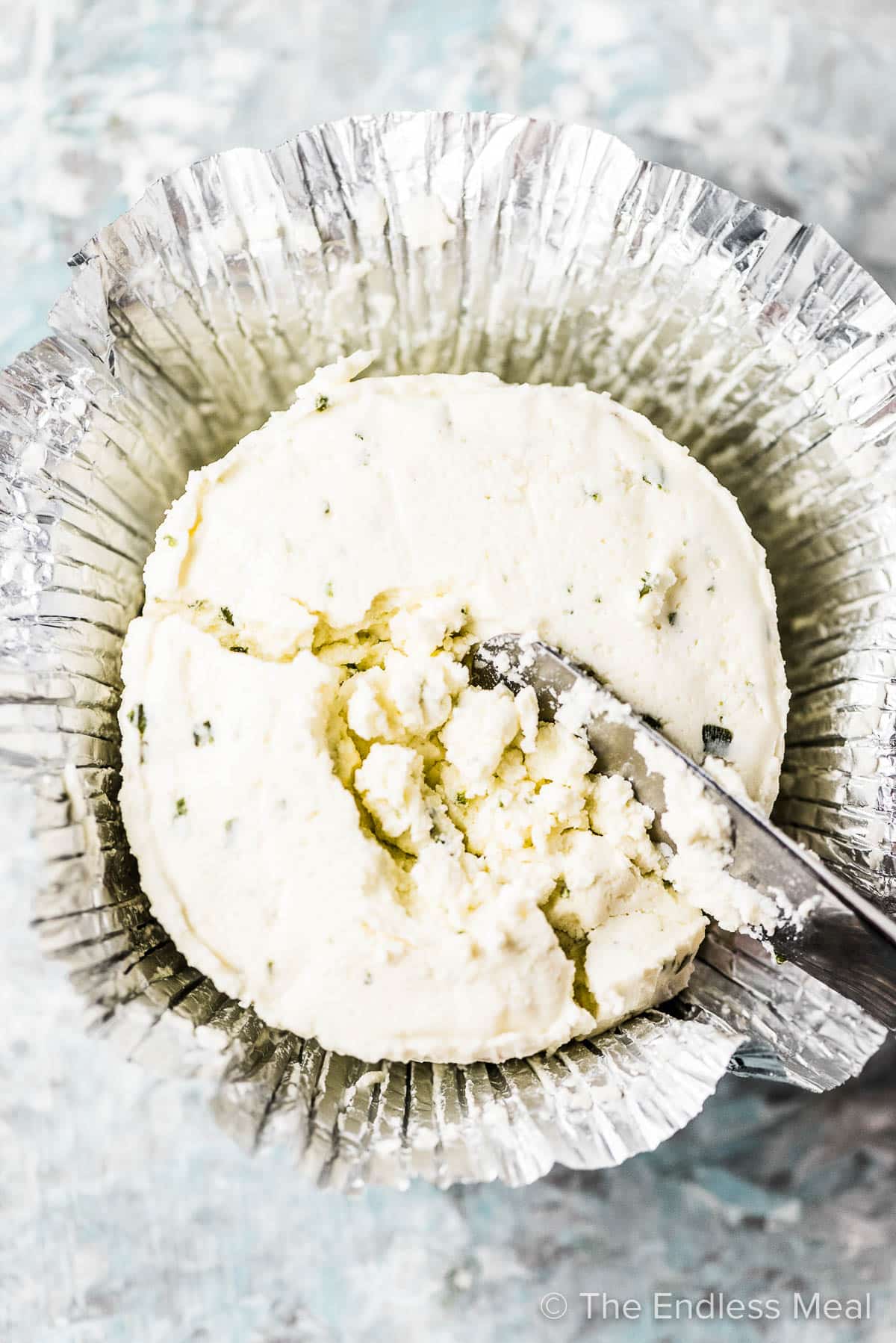 Boursin cheese with a knife in it.