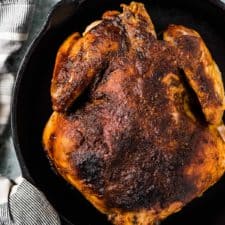 Crockpot roast chicken in a black pan.
