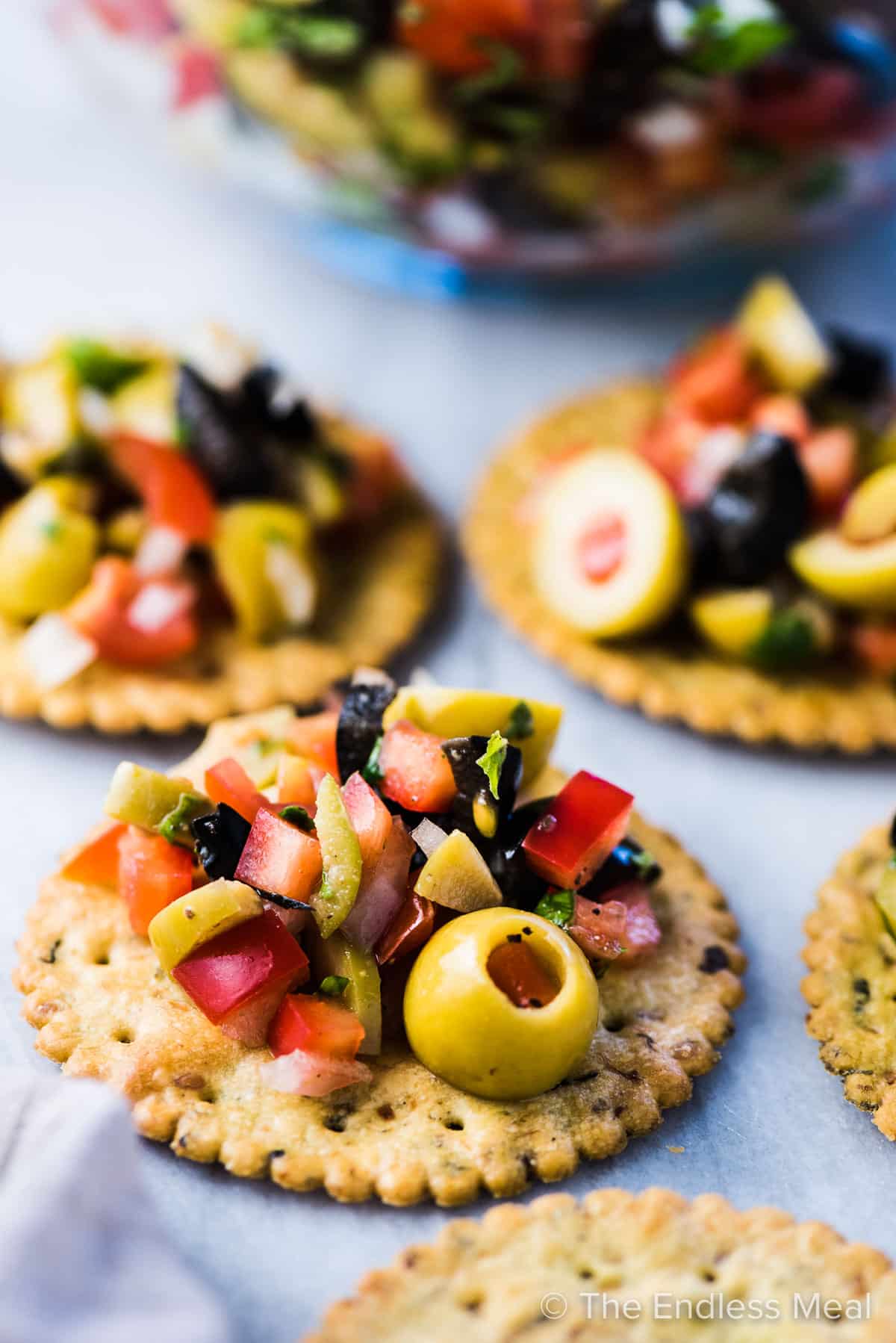 Olive salsa piled on top of crackers.