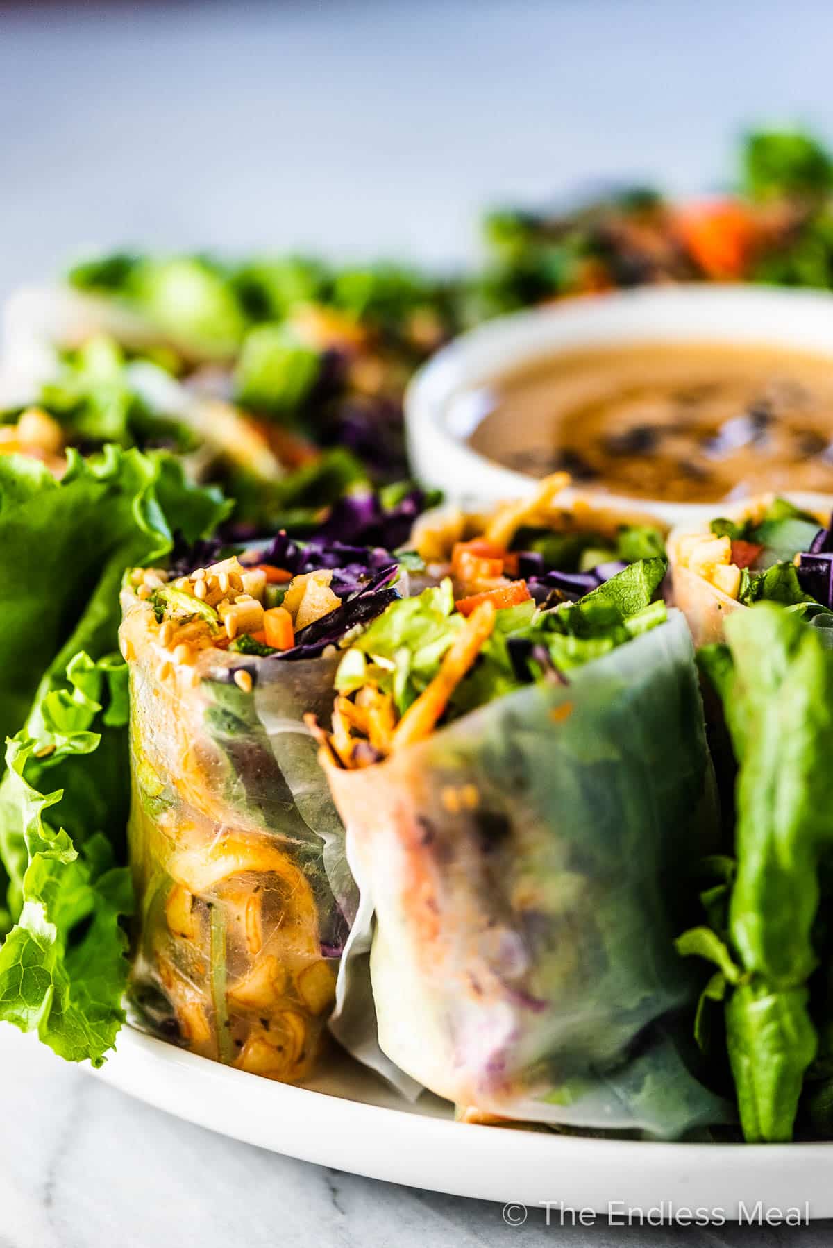 Fresh spring rolls cut in half and stacked on a plate.