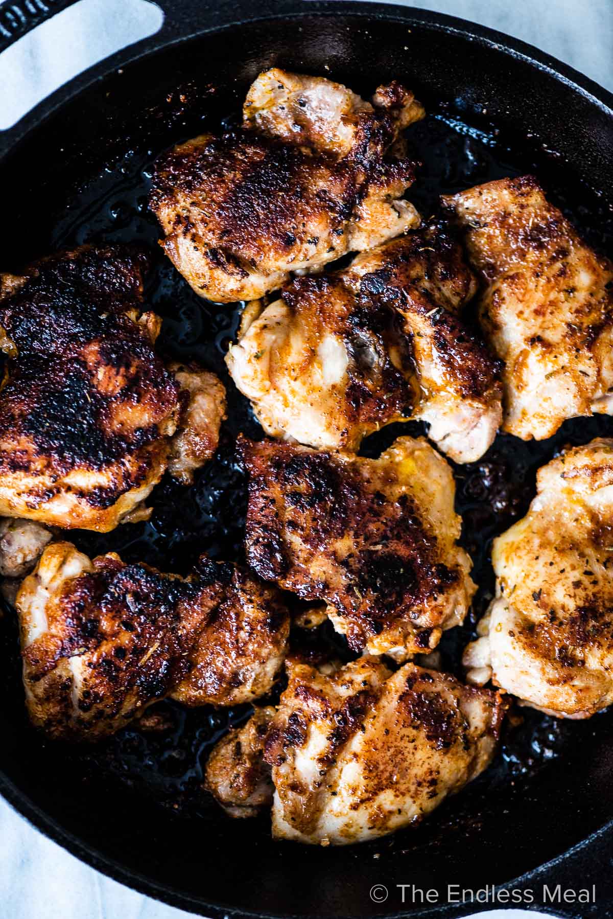Pan seared garlic chicken thighs in a pan.