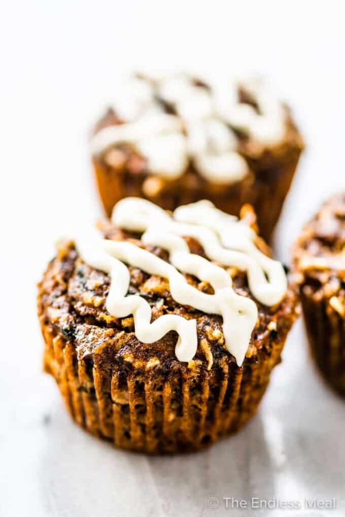 Healthy carrot cake muffins with honey cream cheese frosting.