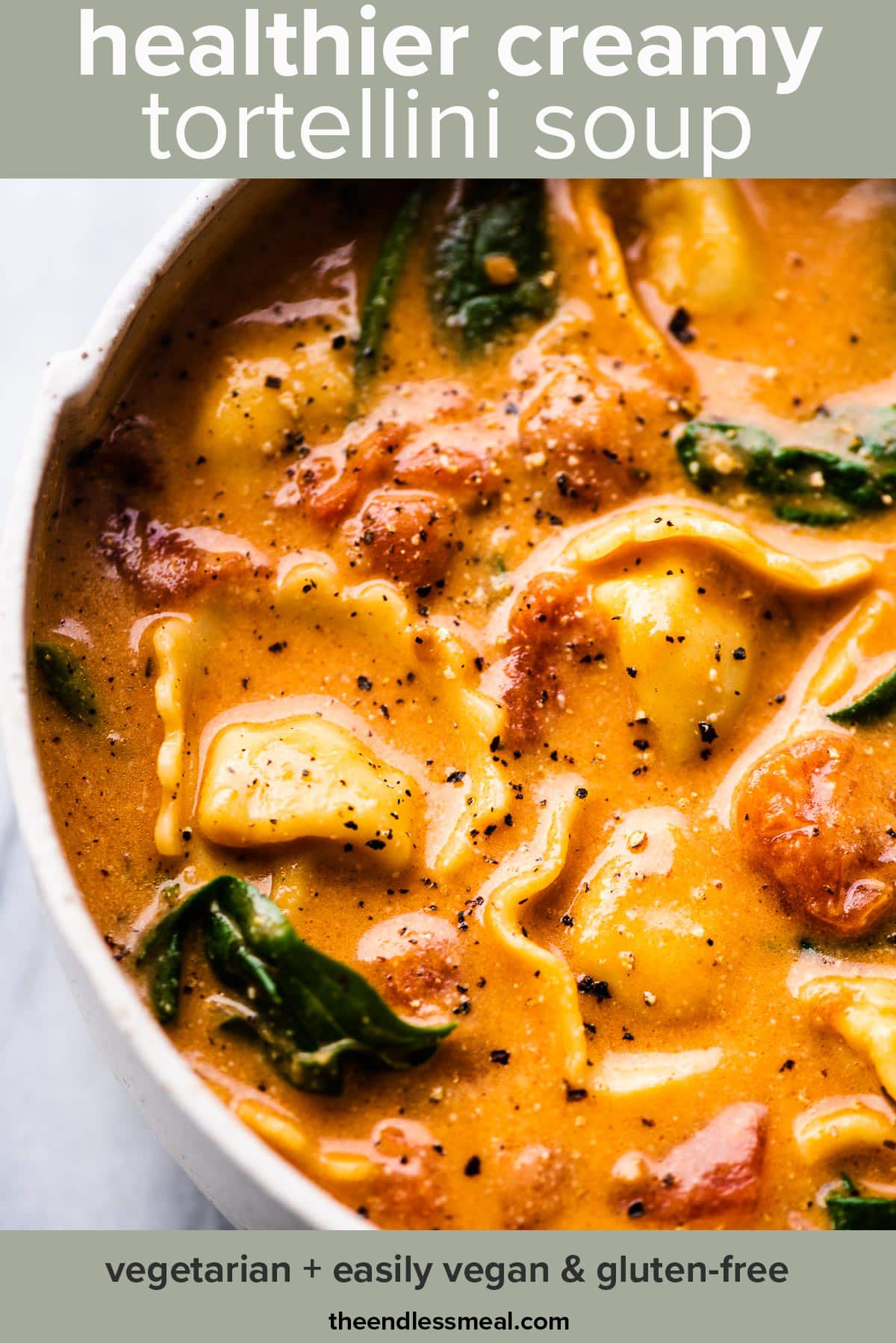 A bowl of healthier creamy tortellini soup with spinach with the post title on the picture.