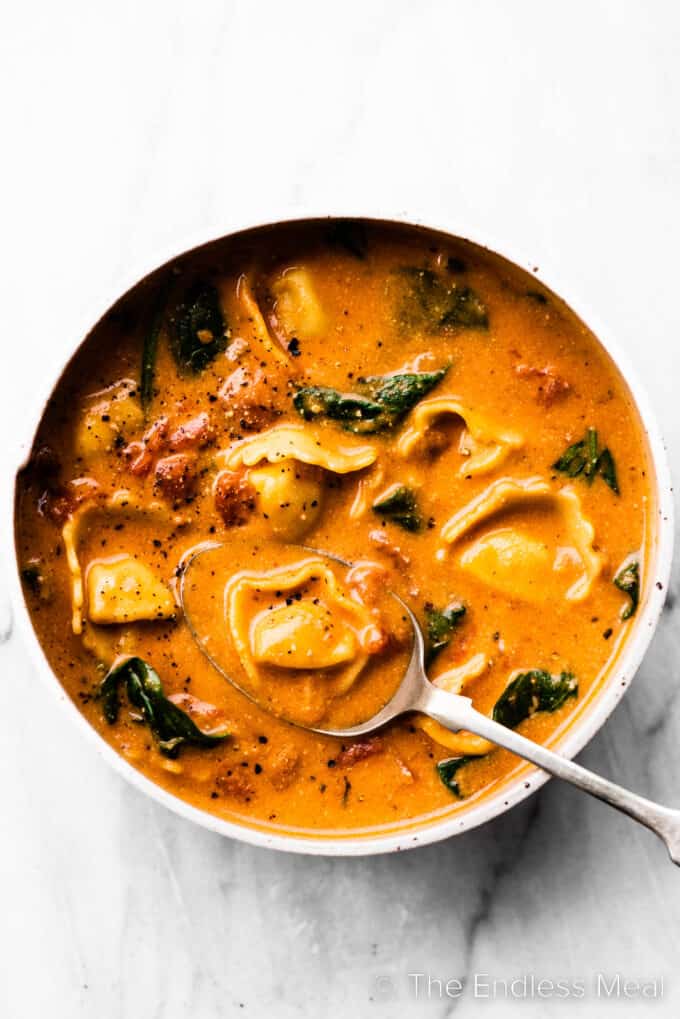Creamy Tortellini Soup in a bow with a spoon.