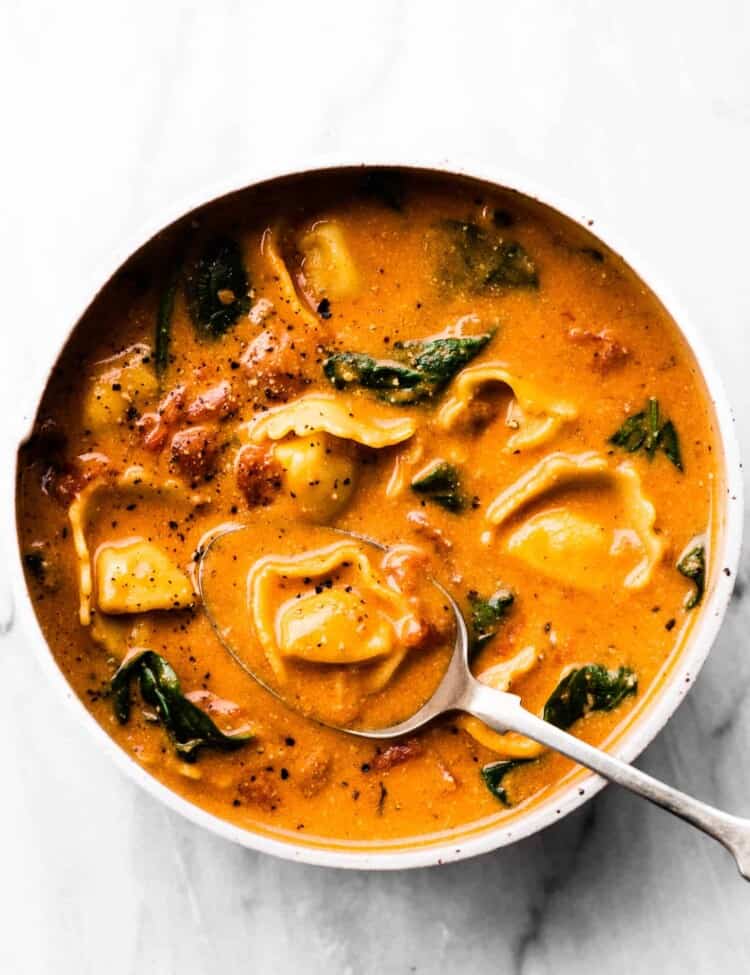 Creamy Tortellini Soup in a bow with a spoon.