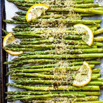 A baking sheet with roasted asparagus lined up on it.