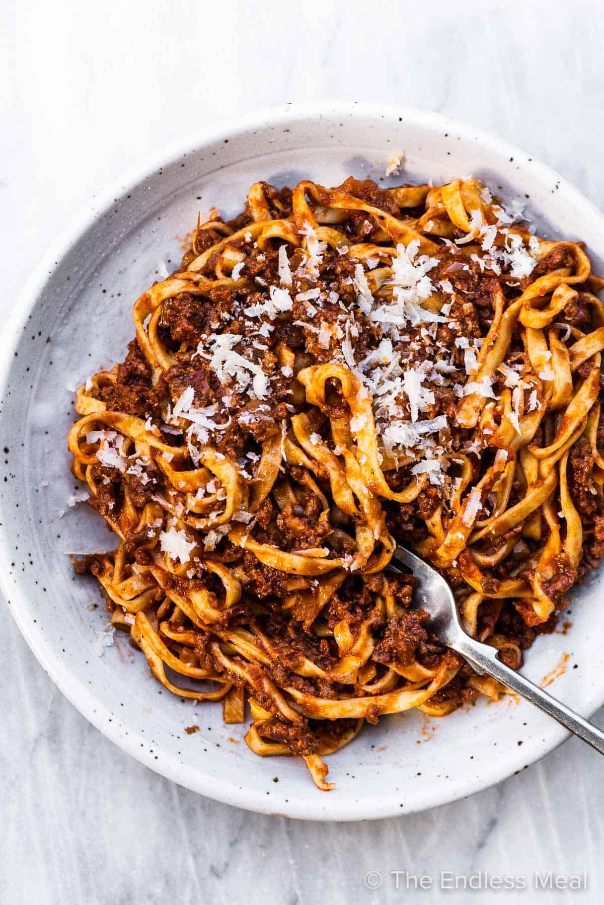 A white pasta bowl filled with homemade spaghetti sauce and pasta.