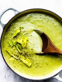 celery soup in a pot with a wooden spoon.