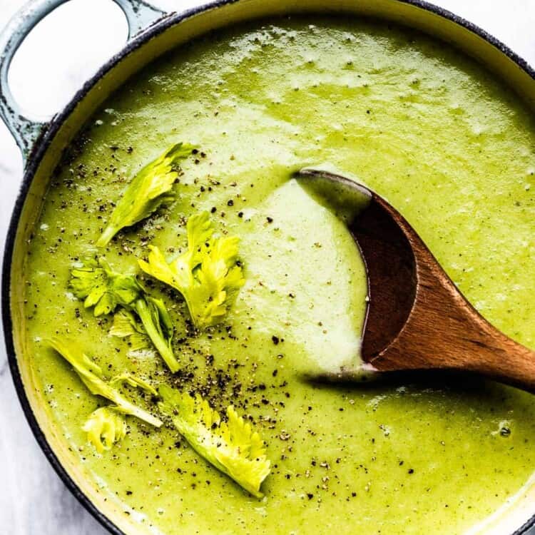 celery soup in a pot with a wooden spoon.