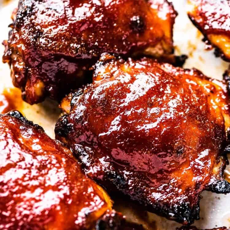 Baked BBQ chicken on a baking sheet.