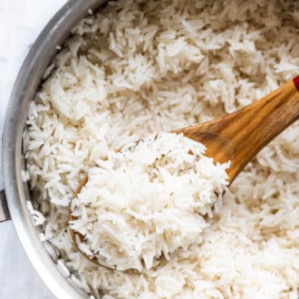 stovetop basmati rice in a pot with a wooden spoon.