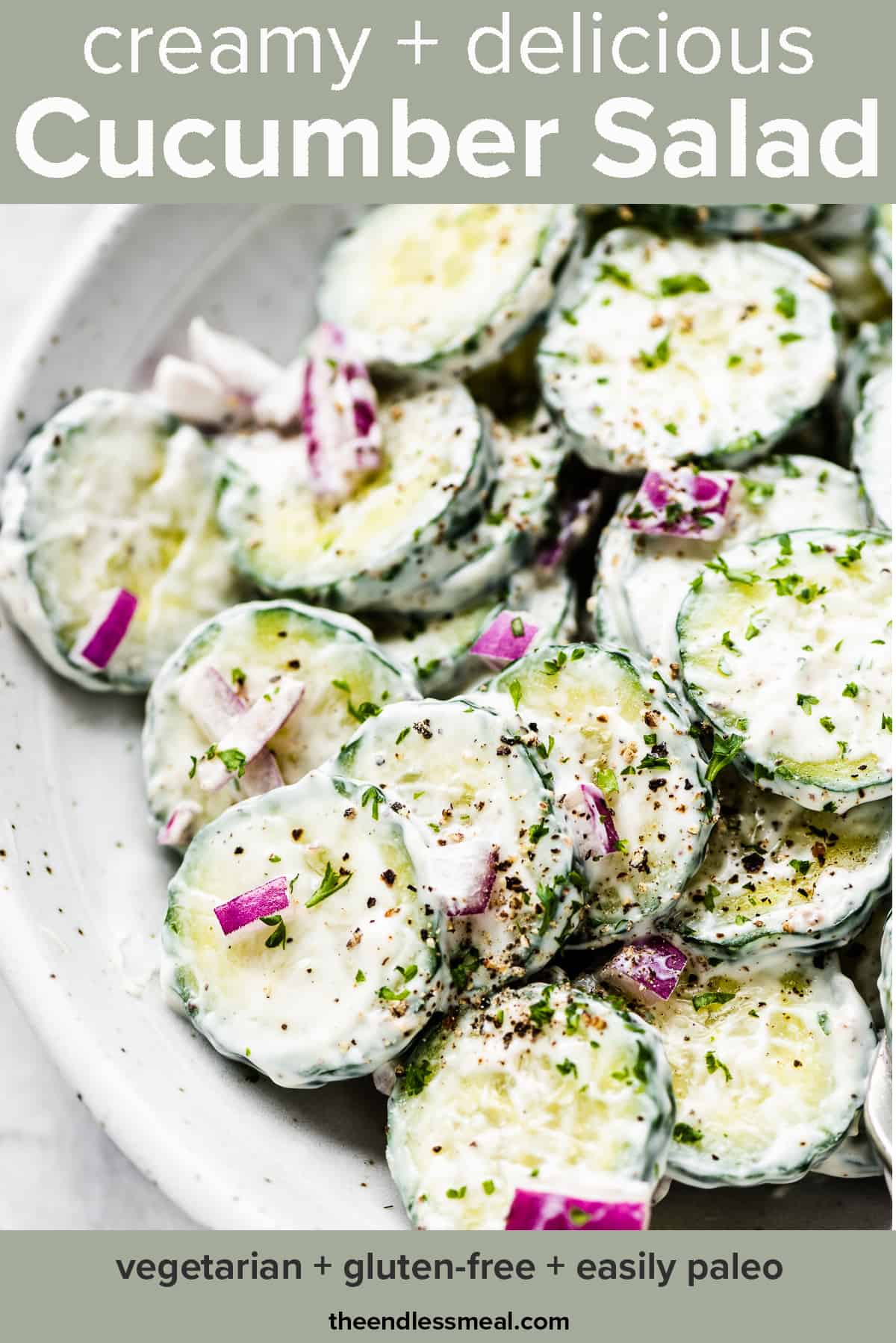 A close up of this creamy cucumber salad in a white serving bowl with the recipe title on top of the picture.