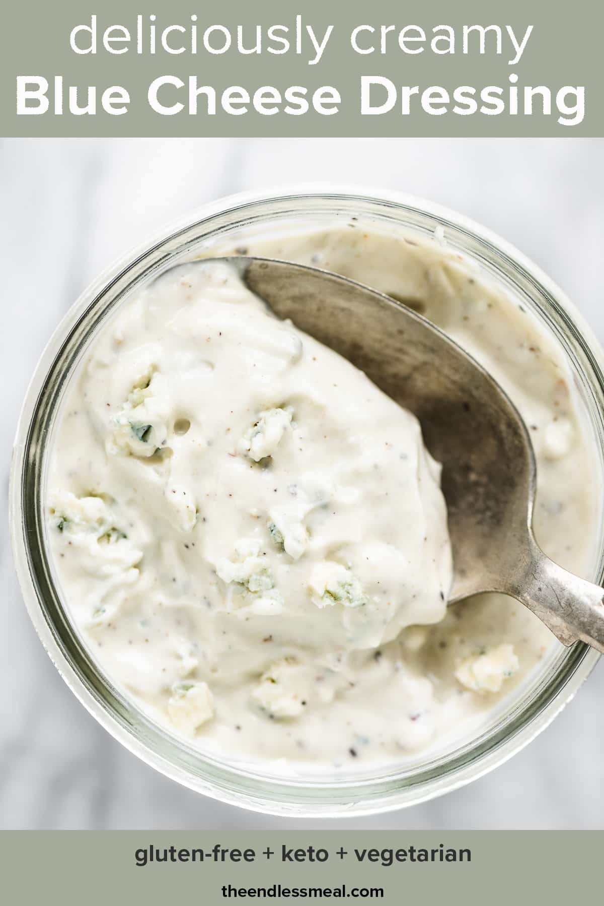 Blue cheese dressing in a jar with a spoon taking a scoop and the recipe title on top of the picture.