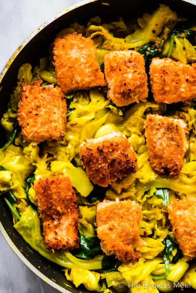 A pan with crispy salmon and cabbage.