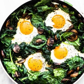 Spinach and eggs in a frying pan.