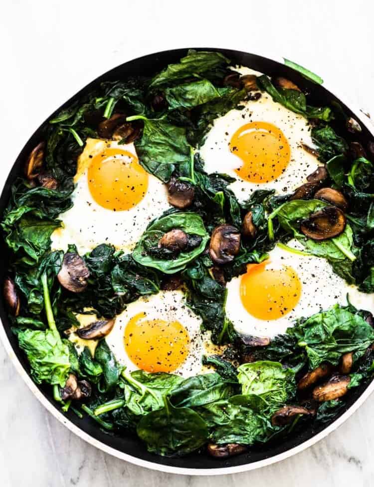 Spinach and eggs in a frying pan.