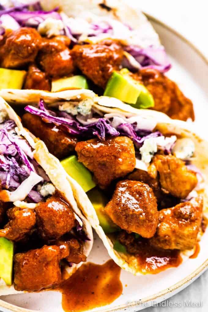 Buffalo chicken tacos on a white plate.