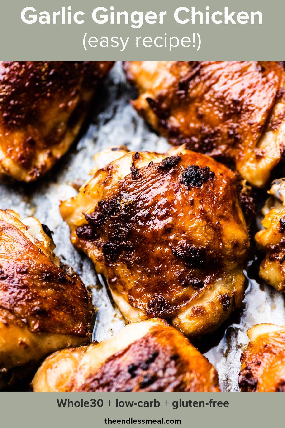 A closeup of garlic ginger chicken thighs on a baking tray and the recipe title on top of the picture.