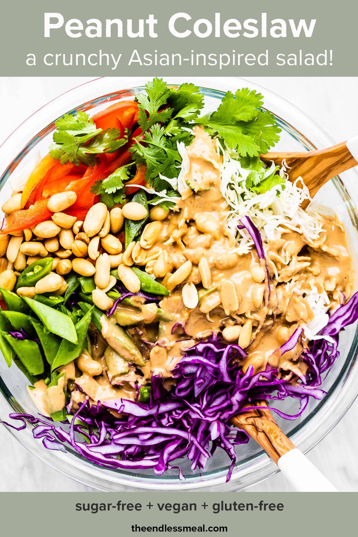 A glass bowl filled with peanut coleslaw with the recipe title on top.