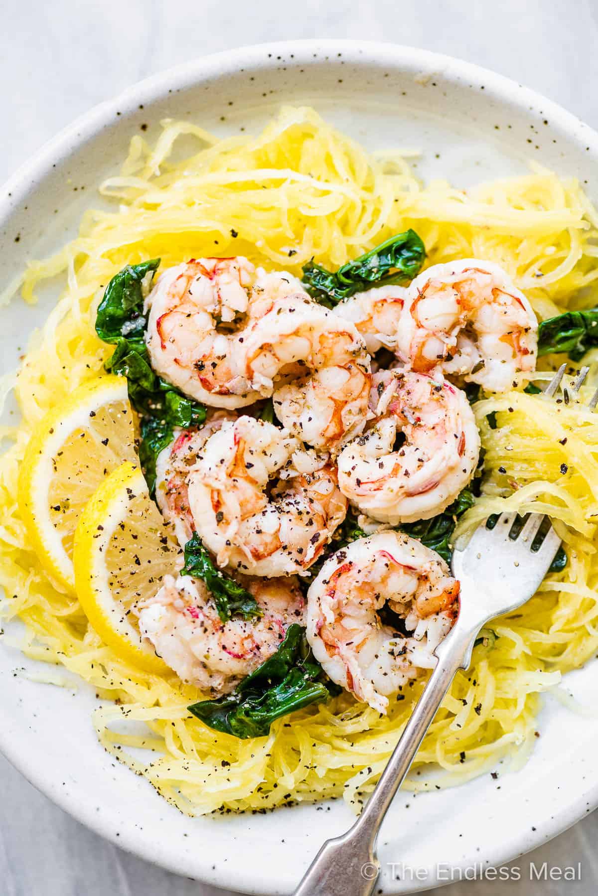 A white plate with spaghetti squash and shrimp scampi on top.