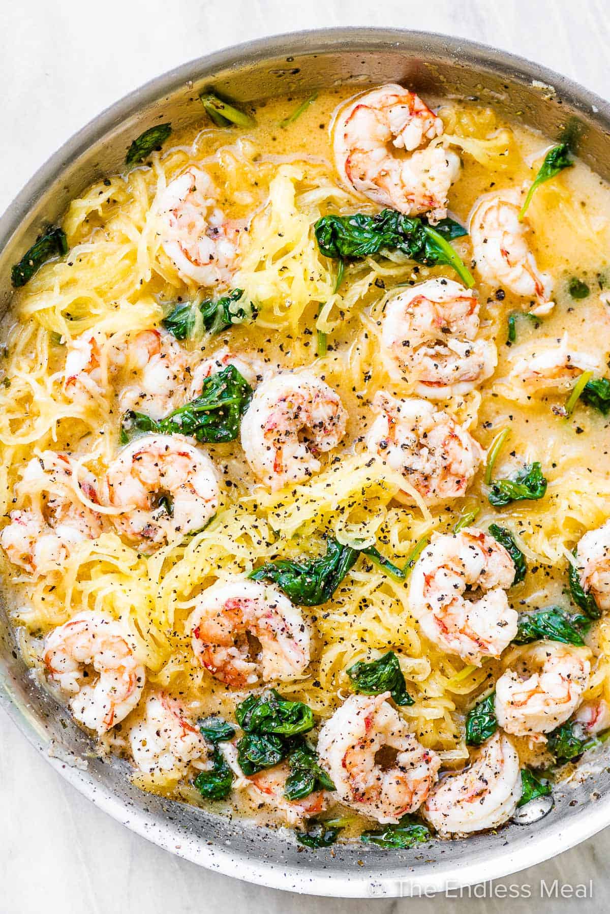 Spaghetti squash shrimp scampi in a pan with some spinach.