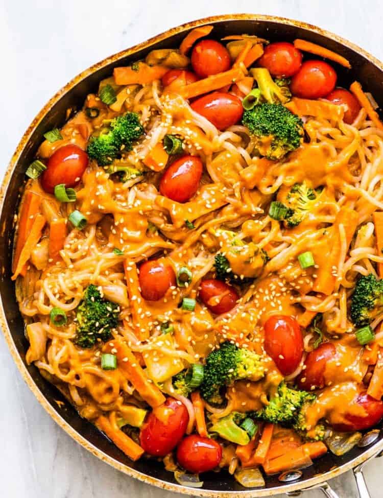 shirataki noodles in a pan with veggies and a peanut sauce.