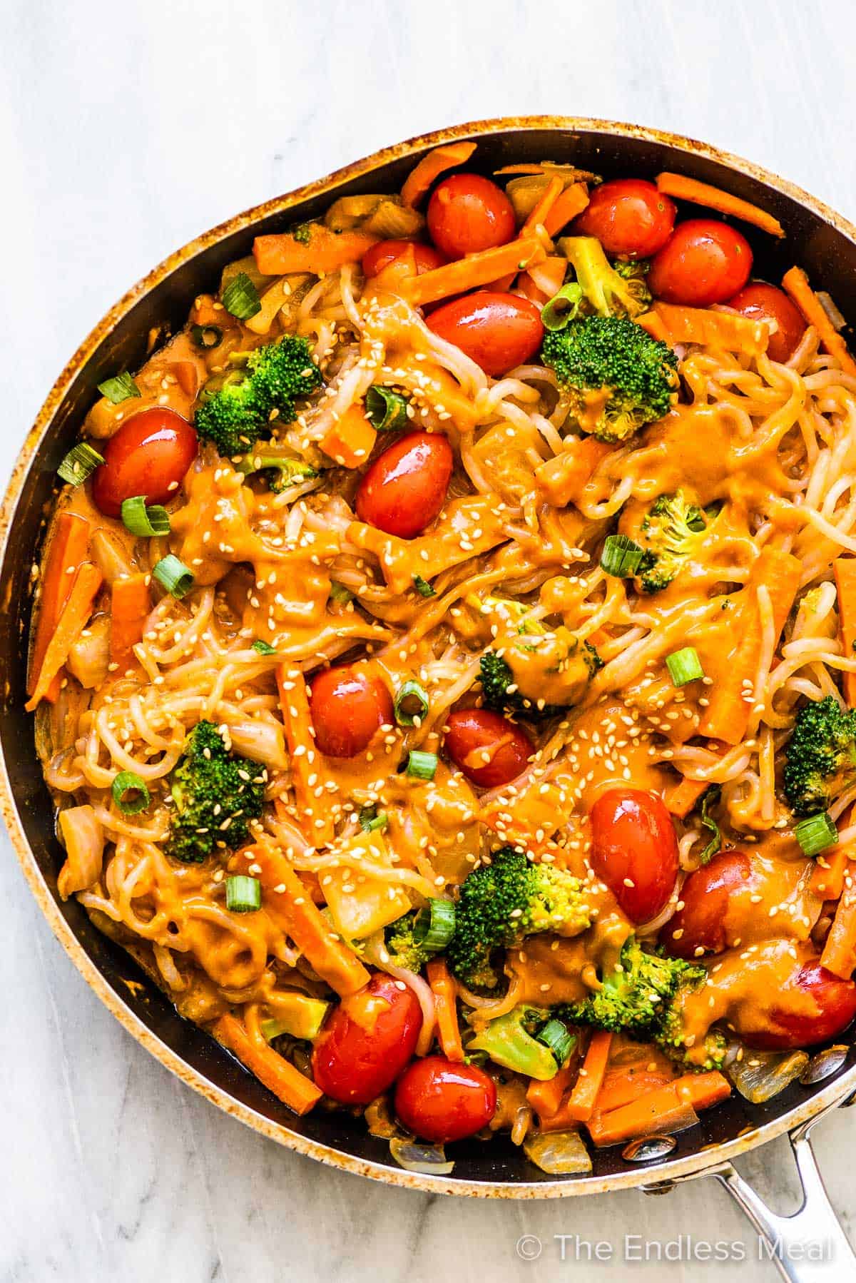 shirataki noodles in a pan with veggies and a peanut sauce.