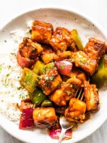 Sweet chili paneer on a white plate with rice.