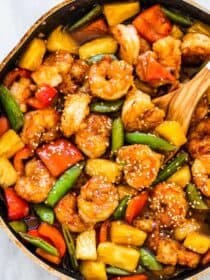 A frying and filled with pineapple shrimp stir fry and lots of veggies.