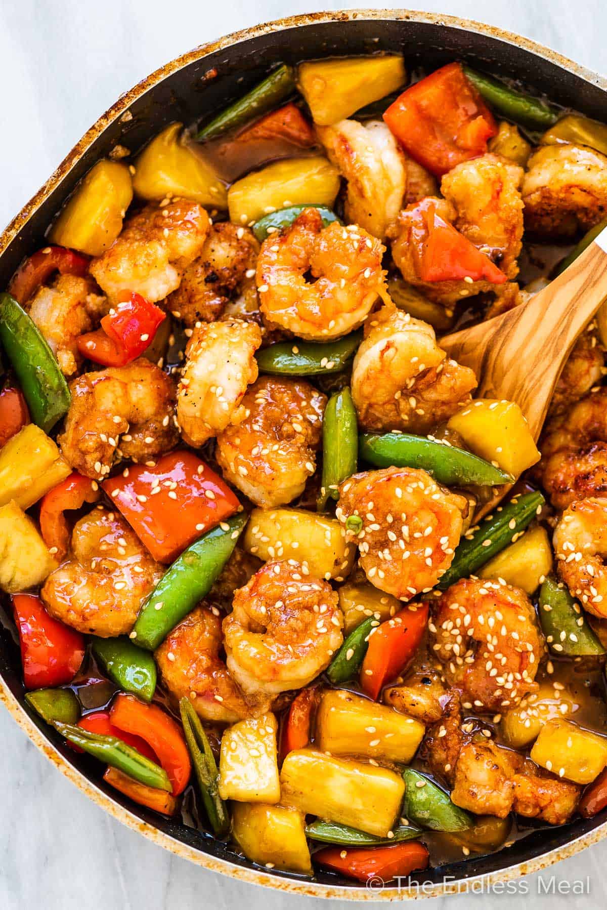 A frying and filled with pineapple shrimp stir fry and lots of veggies.