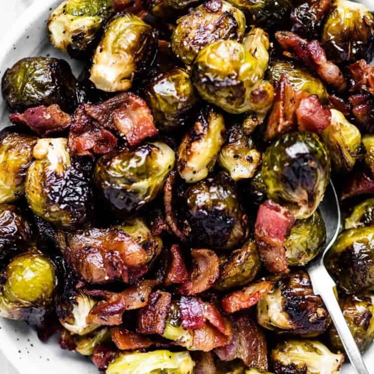 A serving bowl filled with roasted brussels sprouts with bacon.
