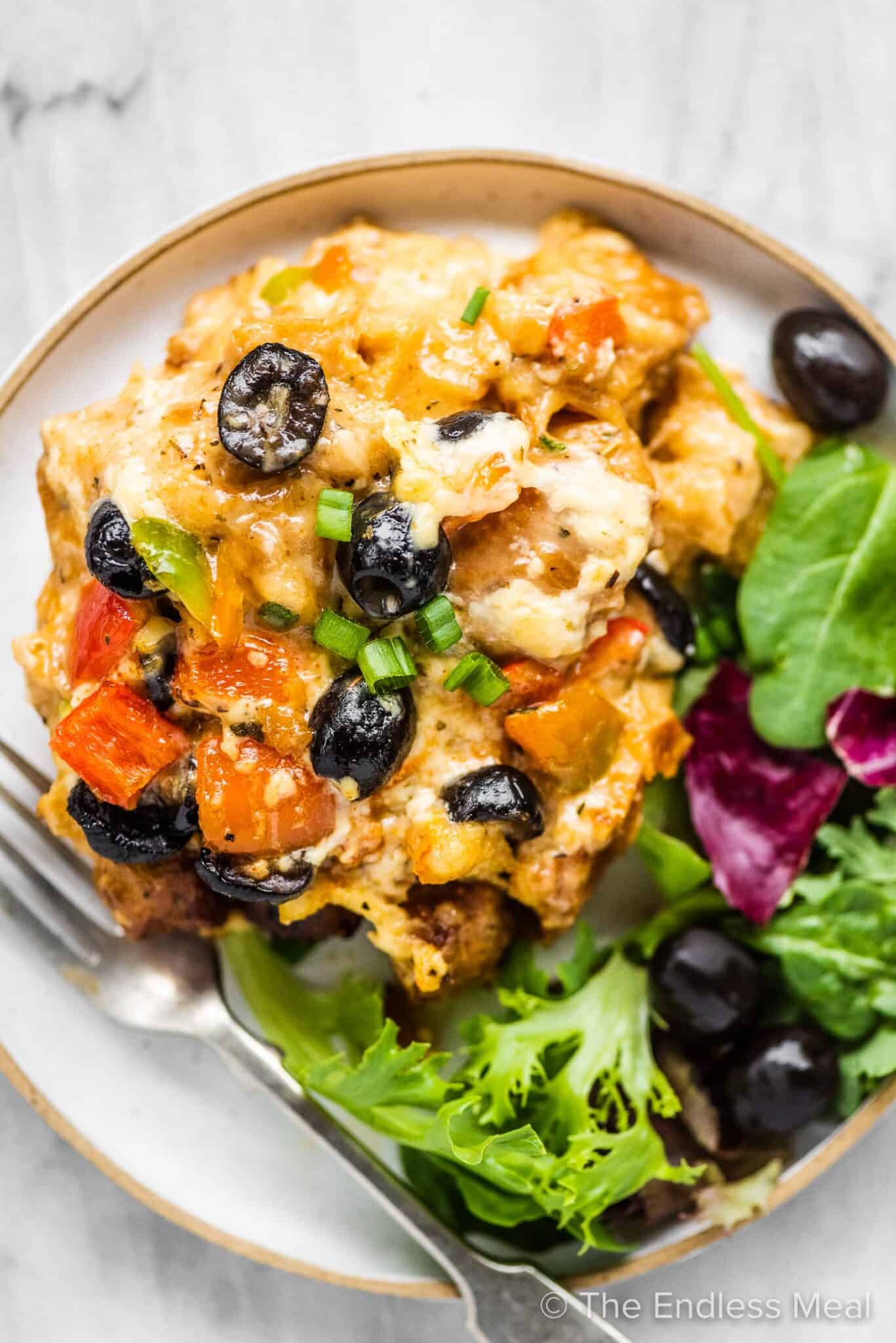 Breakfast strata on a plate with a salad.