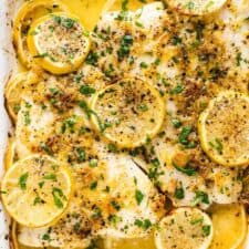 Baked Fish with Lemon Garlic Butter in a white baking dish with parsley on the top.