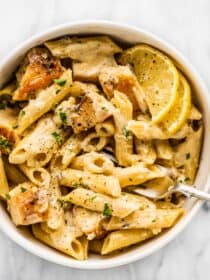 Lemon chicken pasta in a white bowl with a fork,