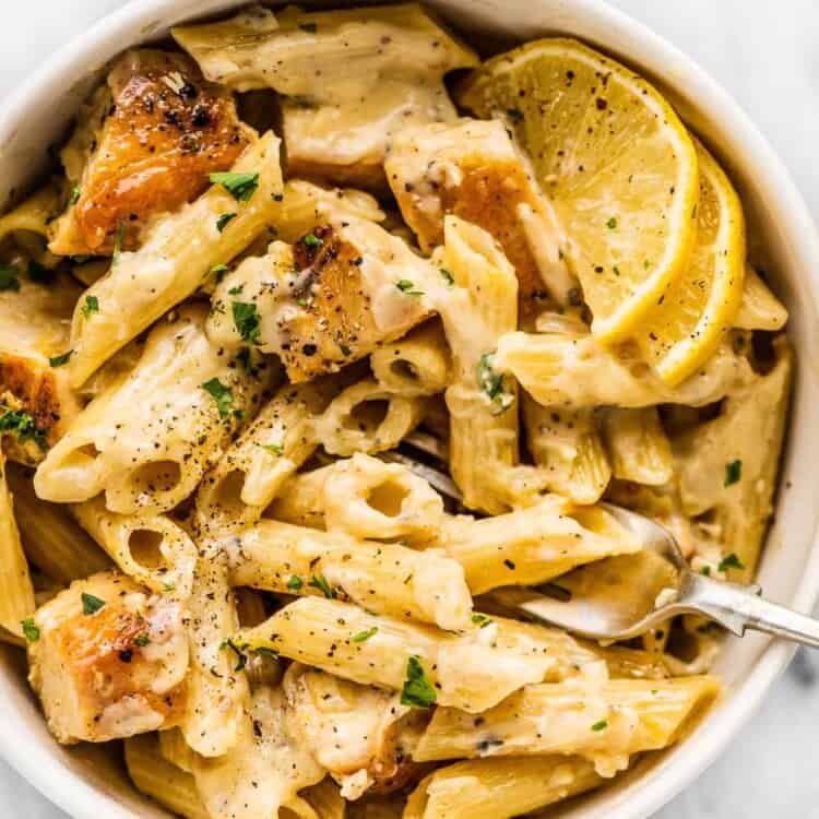 Lemon chicken pasta in a white bowl with a fork,