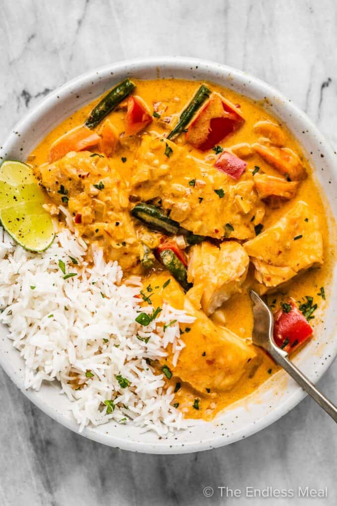 Thai fish curry on a white plate with rice.